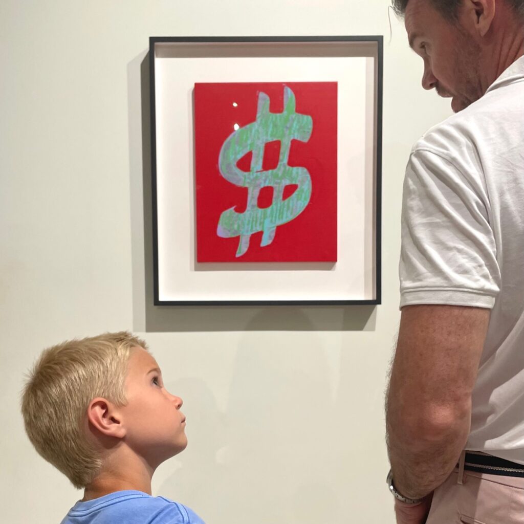 Reed Horth explaining Andy Warhol's "Dollar Sign" original canvas to his son in The MOCO Museum in Barcelona