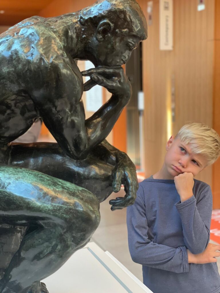 Side view of Auguste Rodin's Le Penseur (The Thinker), monumental bronze sculpture at Art Gallery of Ontario