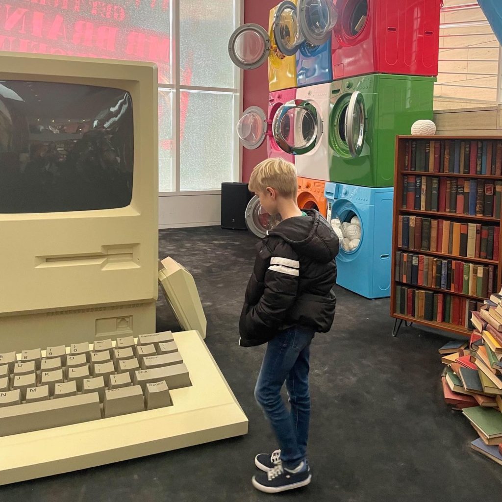 Ronan examines a Gigantic Apple Computer at the new Mr. Brainwash Museum 
